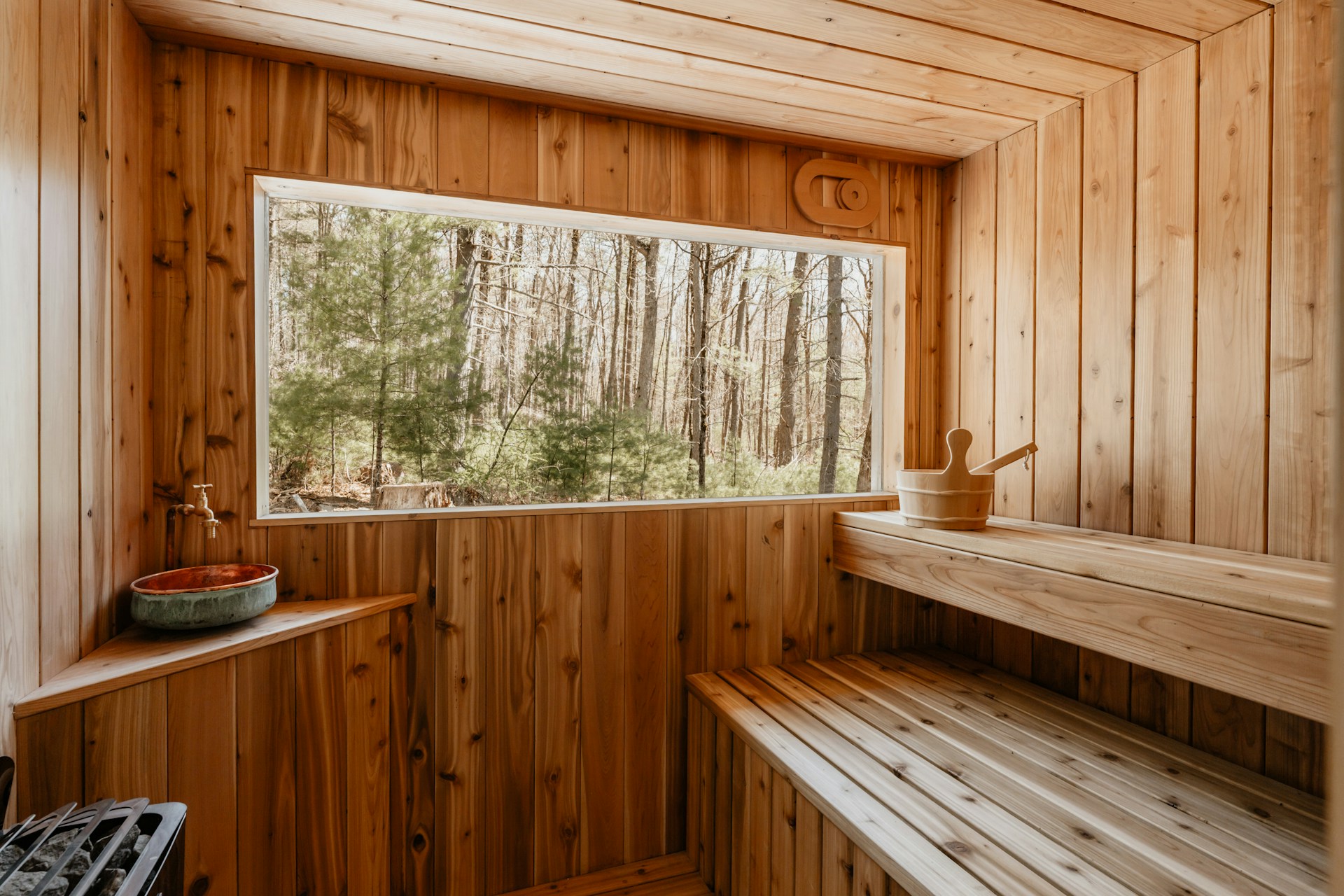 Sauna exterior de madera con vista al bosque